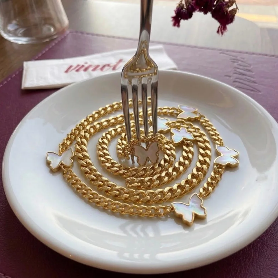 Le collier Céleste enroulé en spirale dans une assiette, autour d'une fourchette